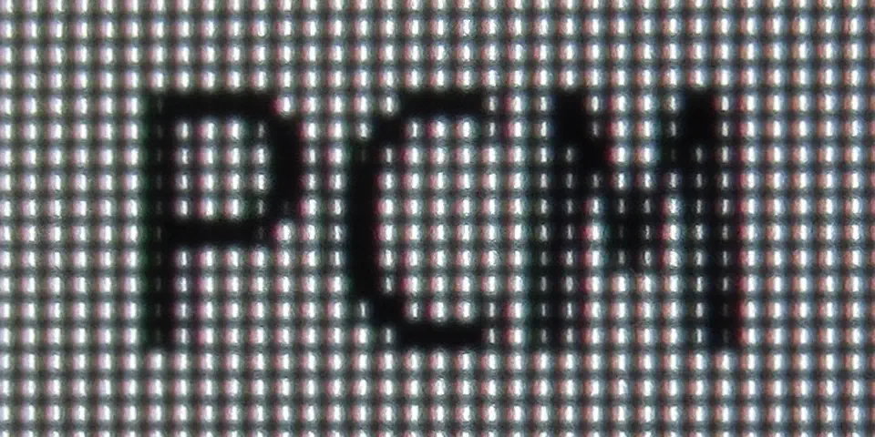 Close-up macro of a WOLED panel showing the red, white, blue, green subpixel stripe layout