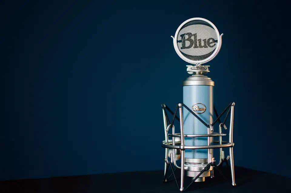 Blue condenser microphone on a desk, the type of USB mic suitable for voice recording