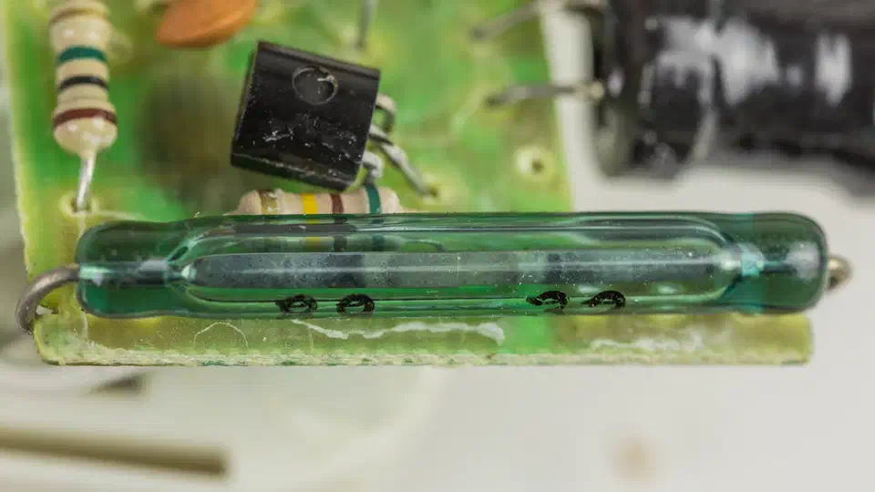 Magnetic reed switch contact sensor mounted on a door frame for open/closed detection