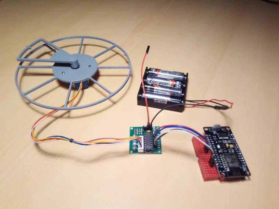 Assembled 3D-printed auger-based cat feeder prototype showing the motor, support structure, and dispensing tube
