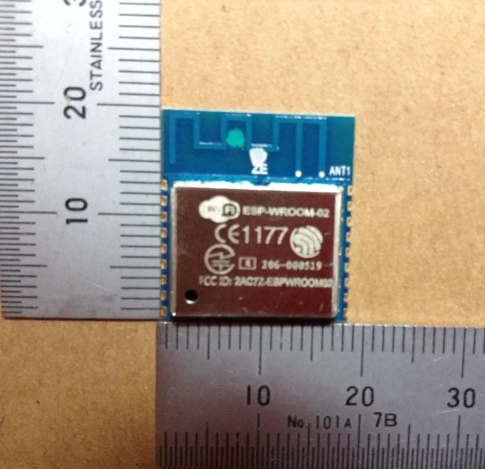 ESP-WROOM-02 module, a small square metal-shielded ESP8266 Wi-Fi board with castellated solder pads along three edges