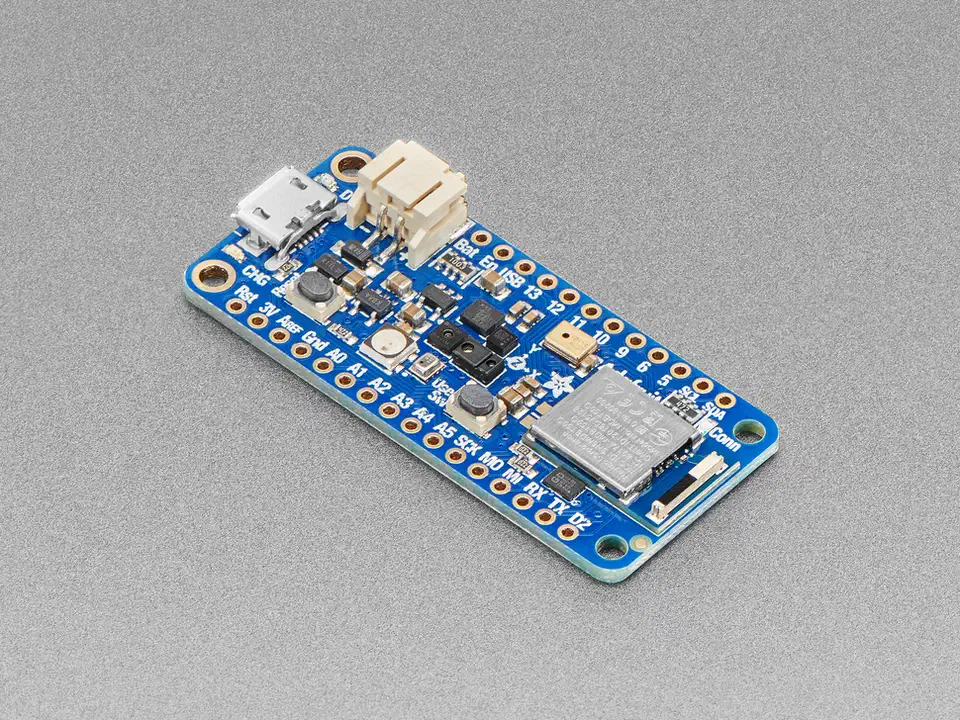 Adafruit Feather nRF52840 Sense board angled view showing the blue PCB with onboard sensors, USB connector, and Feather form factor